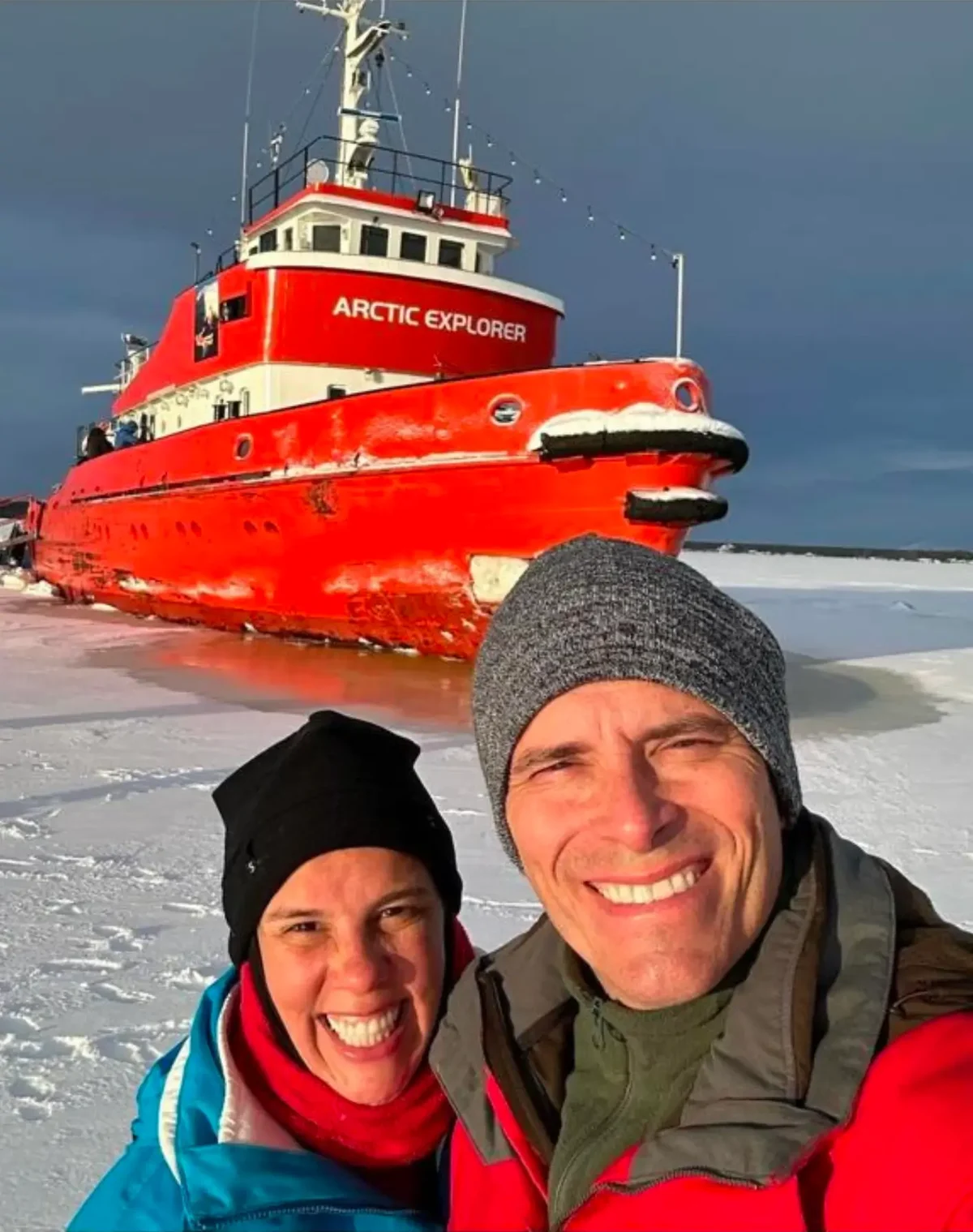 Gustavo e Adriana diante de um navio no Ártico
